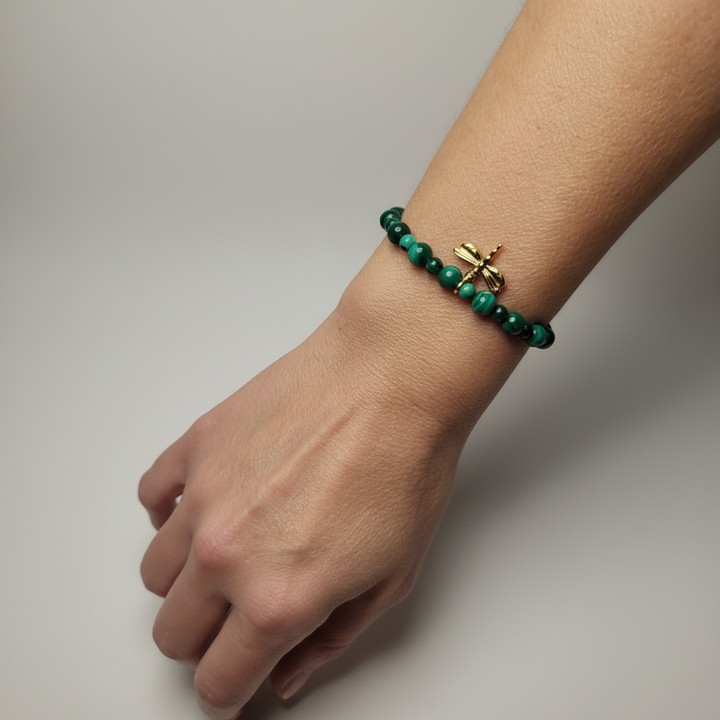 Bracelet perles Malachite et breloque Libellule dorée - porté au poignet fond neutre