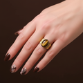 Bague large striée œil de tigre portée sur main mannequin - fond chocolat